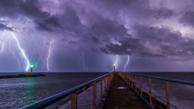 Port and lighthouse overnight storm with lightning in Port-la-Nouvelle